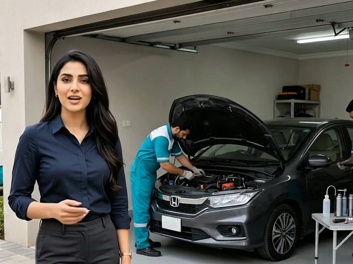 A Car Cure advisor standing beside a Honda City being serviced in a home garage
